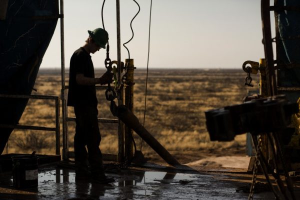 A worker waits to connect a drill bit on Endeavor Energy Resources